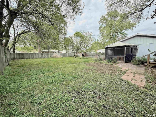 view of yard with a fenced backyard and a sunroom