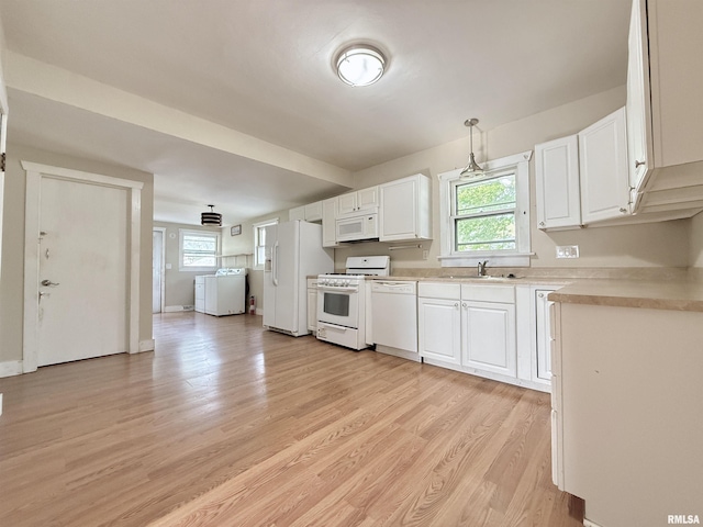 kitchen featuring white appliances, light countertops, white cabinetry, a sink, and light wood-style flooring