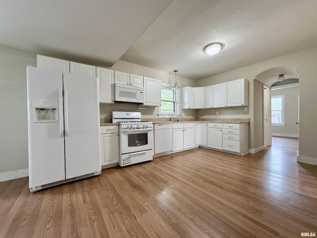 kitchen featuring baseboards, light wood-style flooring, white cabinets, and white appliances