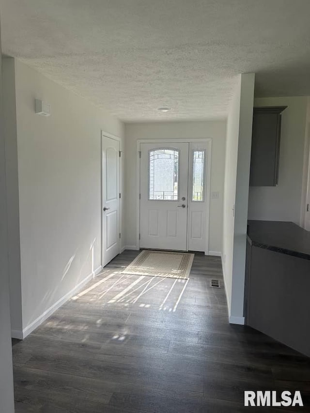entryway featuring baseboards, dark wood-style floors, and a textured ceiling