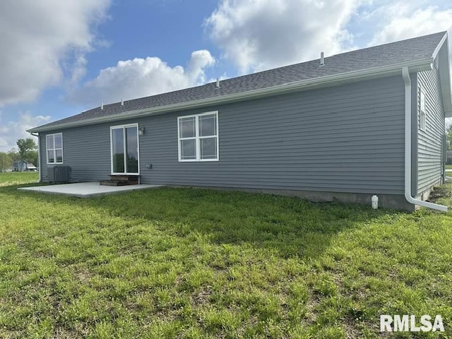 rear view of house with a lawn, central air condition unit, and a patio area