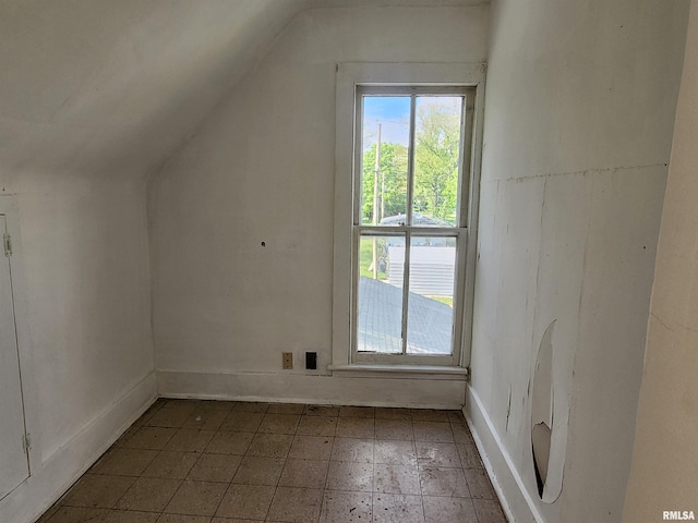 additional living space featuring baseboards and lofted ceiling