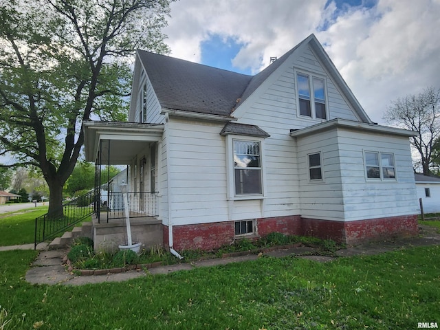 view of home's exterior featuring a yard and roof with shingles