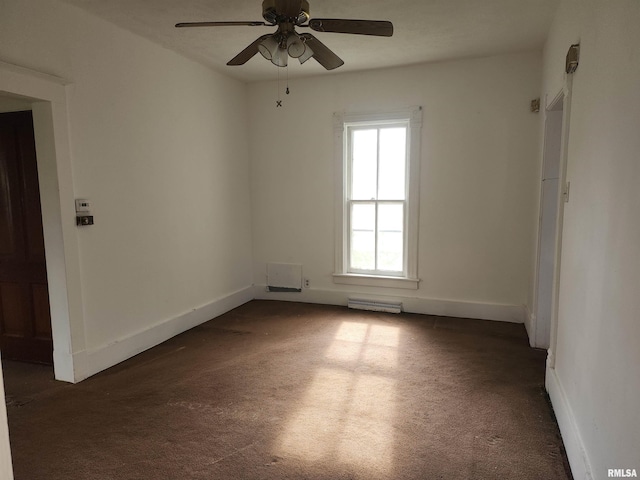 spare room with baseboards, ceiling fan, dark colored carpet, and visible vents