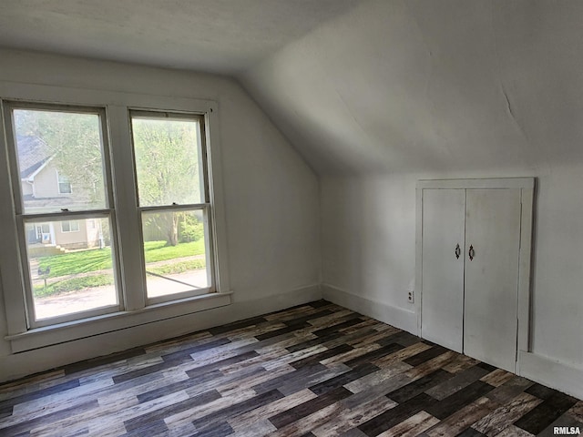 bonus room with dark wood-style flooring and lofted ceiling