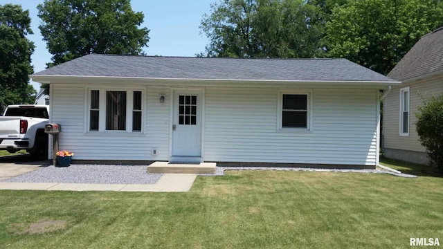 view of front of home featuring a shingled roof and a front lawn
