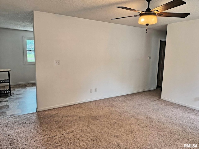 carpeted spare room with baseboards, a textured ceiling, and ceiling fan