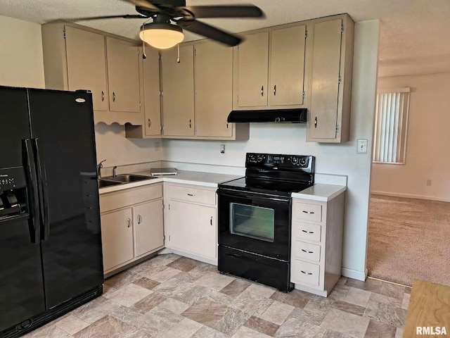 kitchen featuring a sink, light countertops, black appliances, and under cabinet range hood
