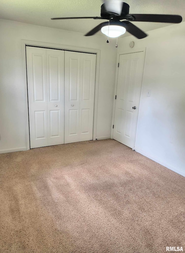 unfurnished bedroom with carpet floors, baseboards, a closet, and ceiling fan