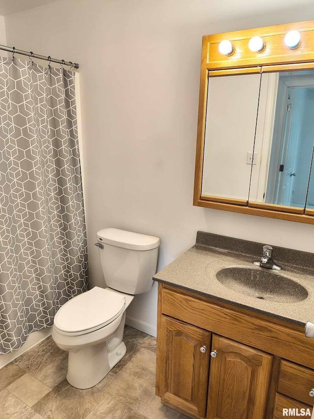bathroom featuring vanity, baseboards, toilet, and curtained shower