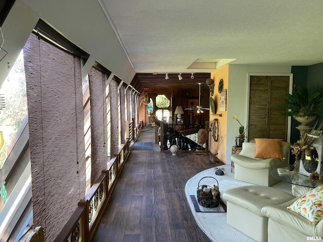 living room with a textured ceiling, wood finished floors, and a ceiling fan