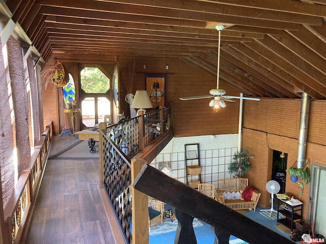 staircase featuring wood walls, lofted ceiling, and ceiling fan