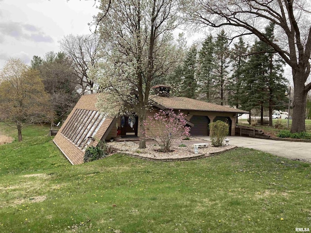 view of front facade with concrete driveway, a front yard, roof with shingles, and a garage