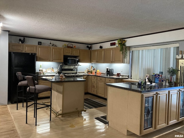 kitchen featuring a center island, freestanding refrigerator, dark countertops, a textured ceiling, and gas stove