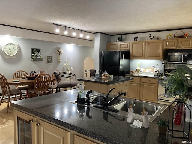 kitchen featuring stainless steel microwave, a sink, freestanding refrigerator, a kitchen island, and dark countertops