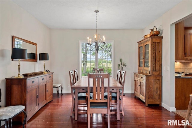 dining area with dark wood finished floors, a chandelier, and baseboards