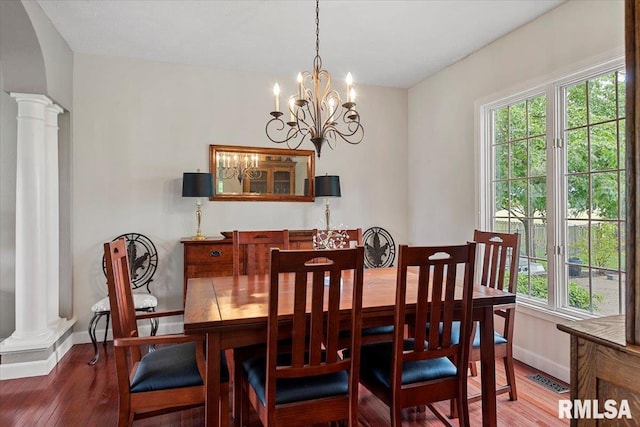 dining space with baseboards, ornate columns, plenty of natural light, and wood finished floors