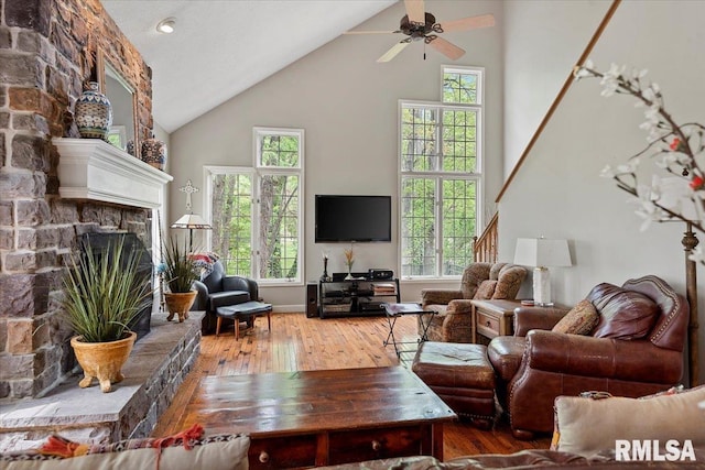 living room with ceiling fan, plenty of natural light, wood-type flooring, and high vaulted ceiling