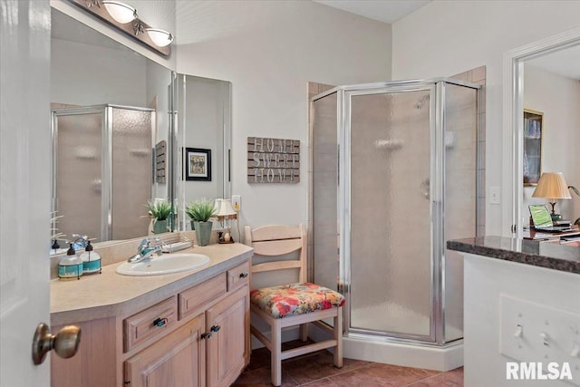 bathroom with a stall shower, tile patterned floors, and vanity