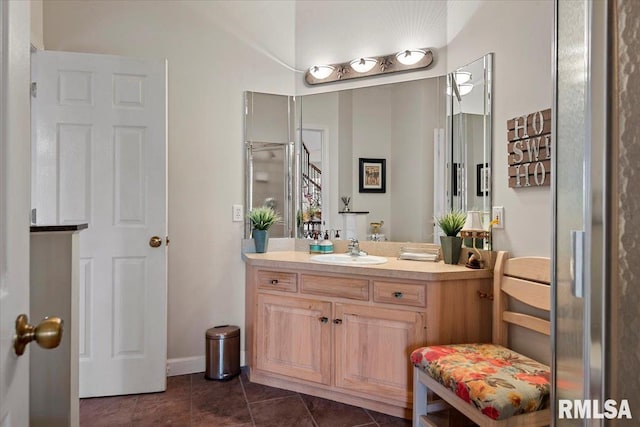 bathroom with baseboards, tile patterned floors, and vanity