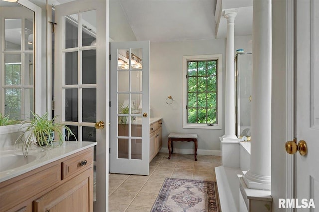 full bathroom with lofted ceiling, vanity, ornate columns, tile patterned floors, and baseboards