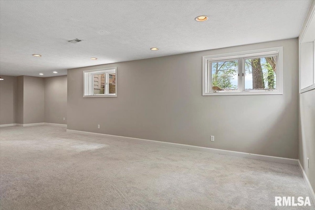 below grade area with baseboards, light carpet, visible vents, and recessed lighting