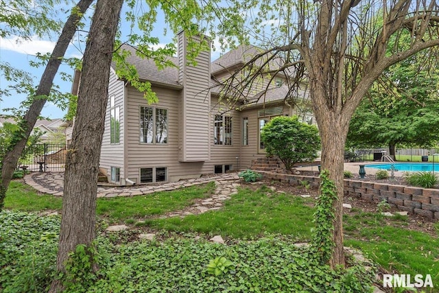 exterior space with a chimney, a fenced in pool, and fence