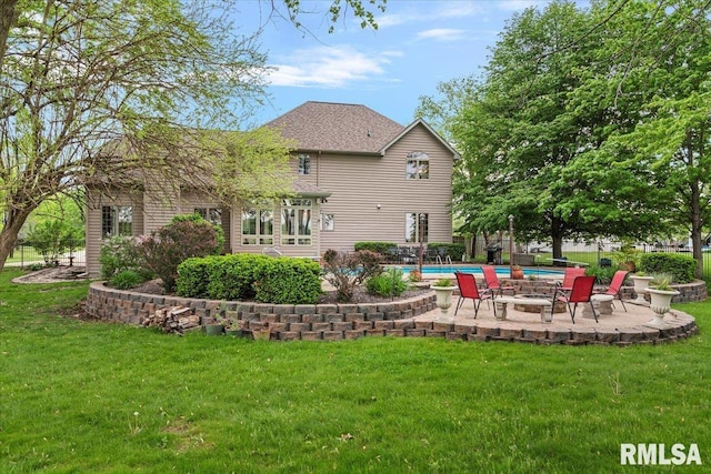 rear view of property with a lawn, a patio, an outdoor pool, and fence