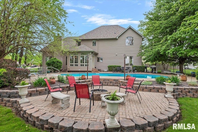 exterior space with a fire pit, a patio, fence, and a fenced in pool