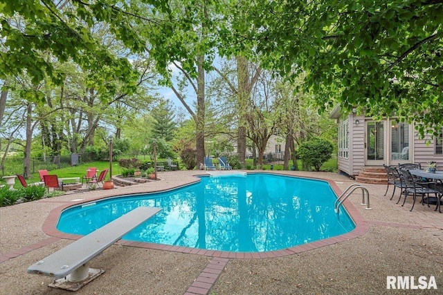 view of pool with a fenced in pool, a diving board, fence, a patio, and entry steps