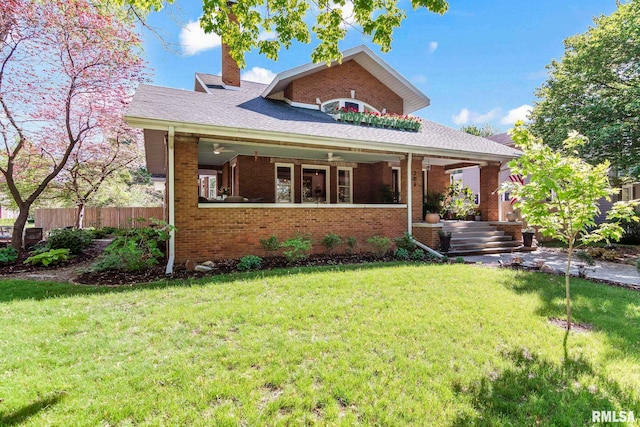 bungalow with fence, a chimney, brick siding, and a front yard