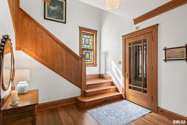 interior space featuring baseboards, stairway, and wood finished floors