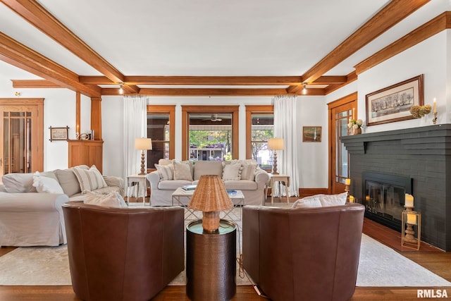 living area featuring coffered ceiling, dark wood-style flooring, a fireplace, and beamed ceiling