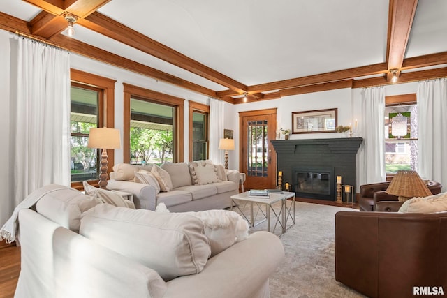 living area featuring a fireplace with flush hearth, coffered ceiling, wood finished floors, and beamed ceiling