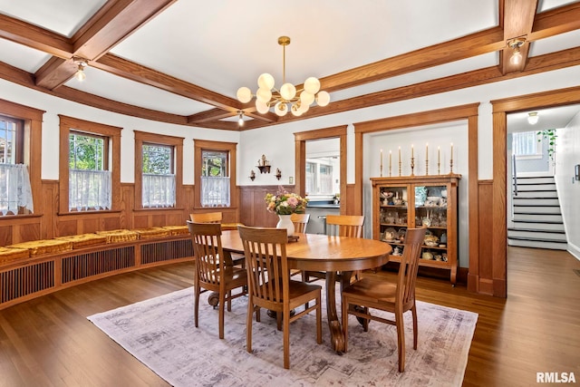 dining space with a wainscoted wall, coffered ceiling, beam ceiling, and stairs