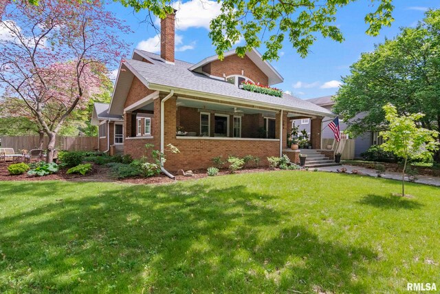 view of front of property with brick siding, fence, and a front yard