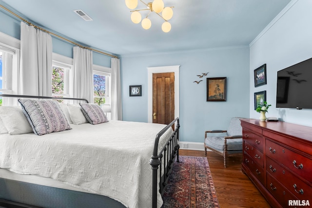 bedroom with dark wood-type flooring, visible vents, crown molding, an inviting chandelier, and baseboards