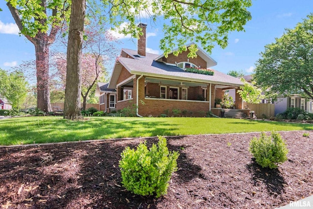 view of front facade featuring a front lawn, brick siding, and a chimney