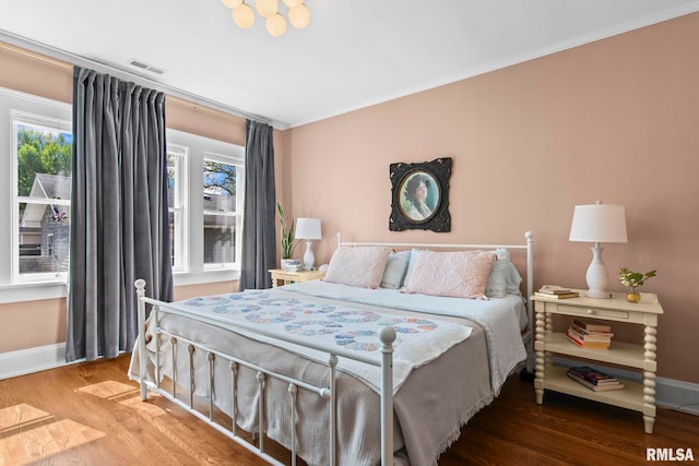 bedroom with crown molding, baseboards, and visible vents