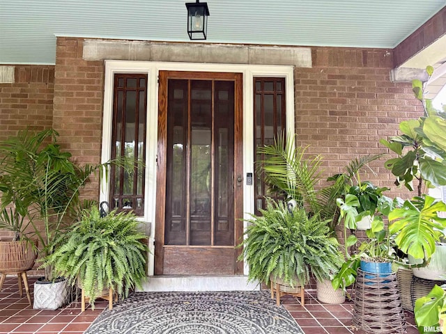 view of exterior entry featuring brick siding
