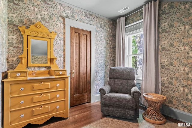 sitting room with wallpapered walls, visible vents, wood finished floors, and baseboards