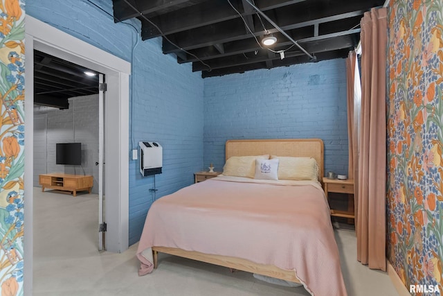 bedroom with finished concrete floors and heating unit