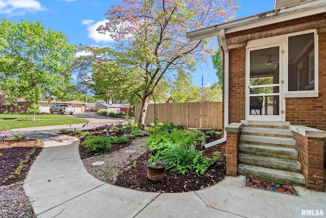 entrance to property with brick siding and fence