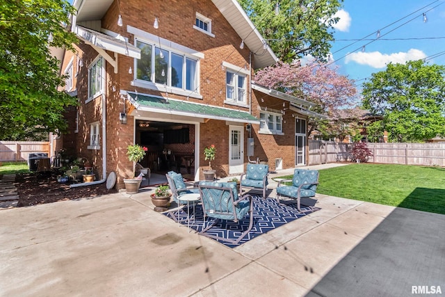 back of house featuring a yard, a patio area, brick siding, and fence