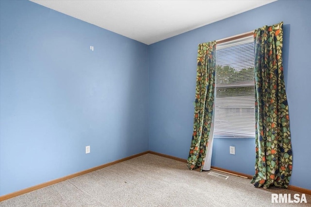 empty room with baseboards, visible vents, and carpet floors