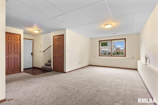 interior space with stairway, baseboards, and a paneled ceiling