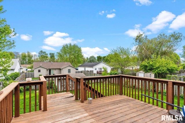 wooden terrace with a fenced backyard, a storage shed, an outbuilding, and a residential view