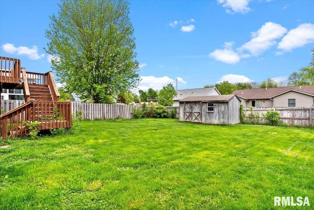 view of yard with an outbuilding, stairway, a fenced backyard, and a storage unit