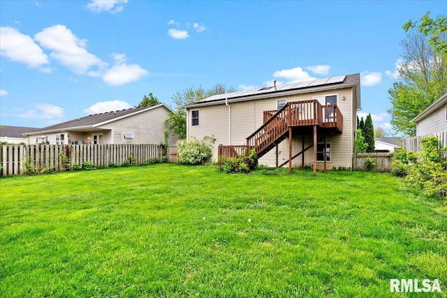 back of property featuring a yard, solar panels, stairs, a wooden deck, and a fenced backyard