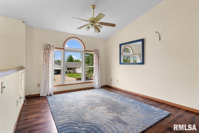 spare room with a ceiling fan, lofted ceiling, baseboards, and wood finished floors